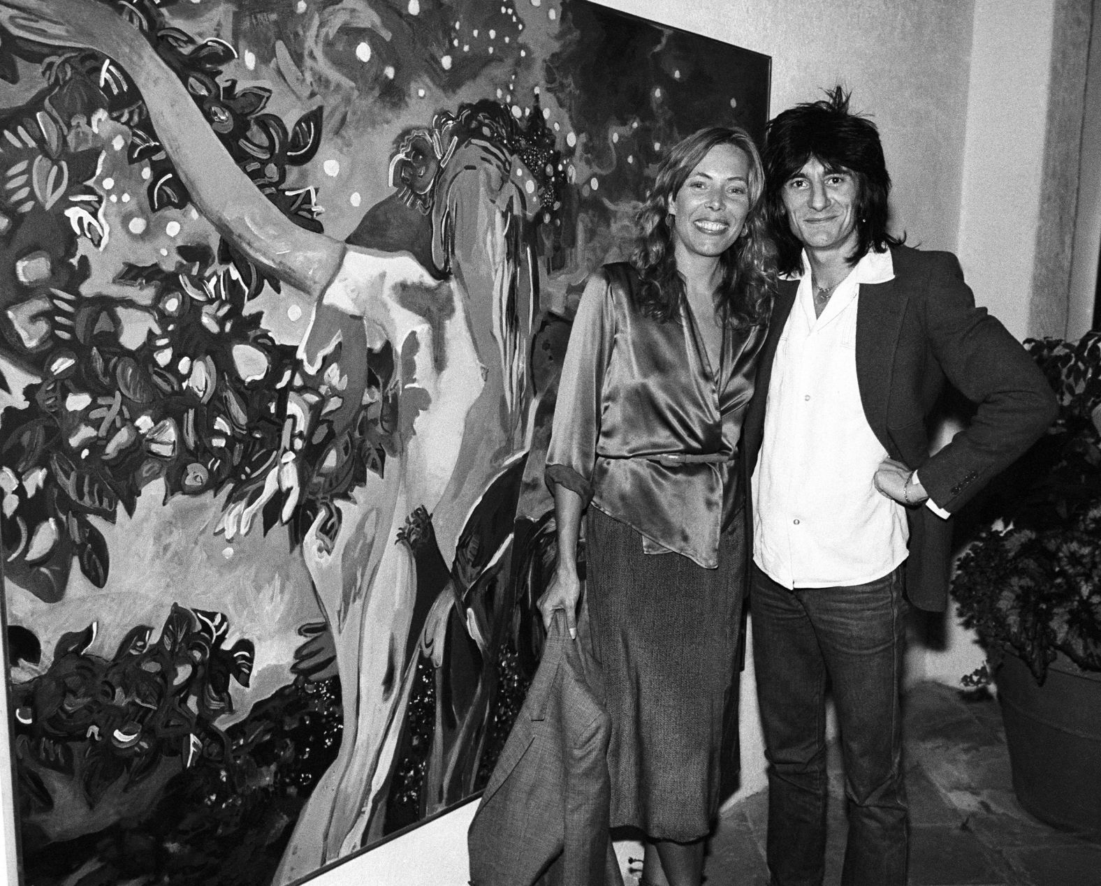 The Rolling Stones guitarist Ronnie Wood joins Mitchell at one of her art exhibitions in Los Angeles, California, in 1977. Mitchell's paintings and drawings have been featured on some of her album covers, as well as those of Crosby, Stills, Nash and Young.