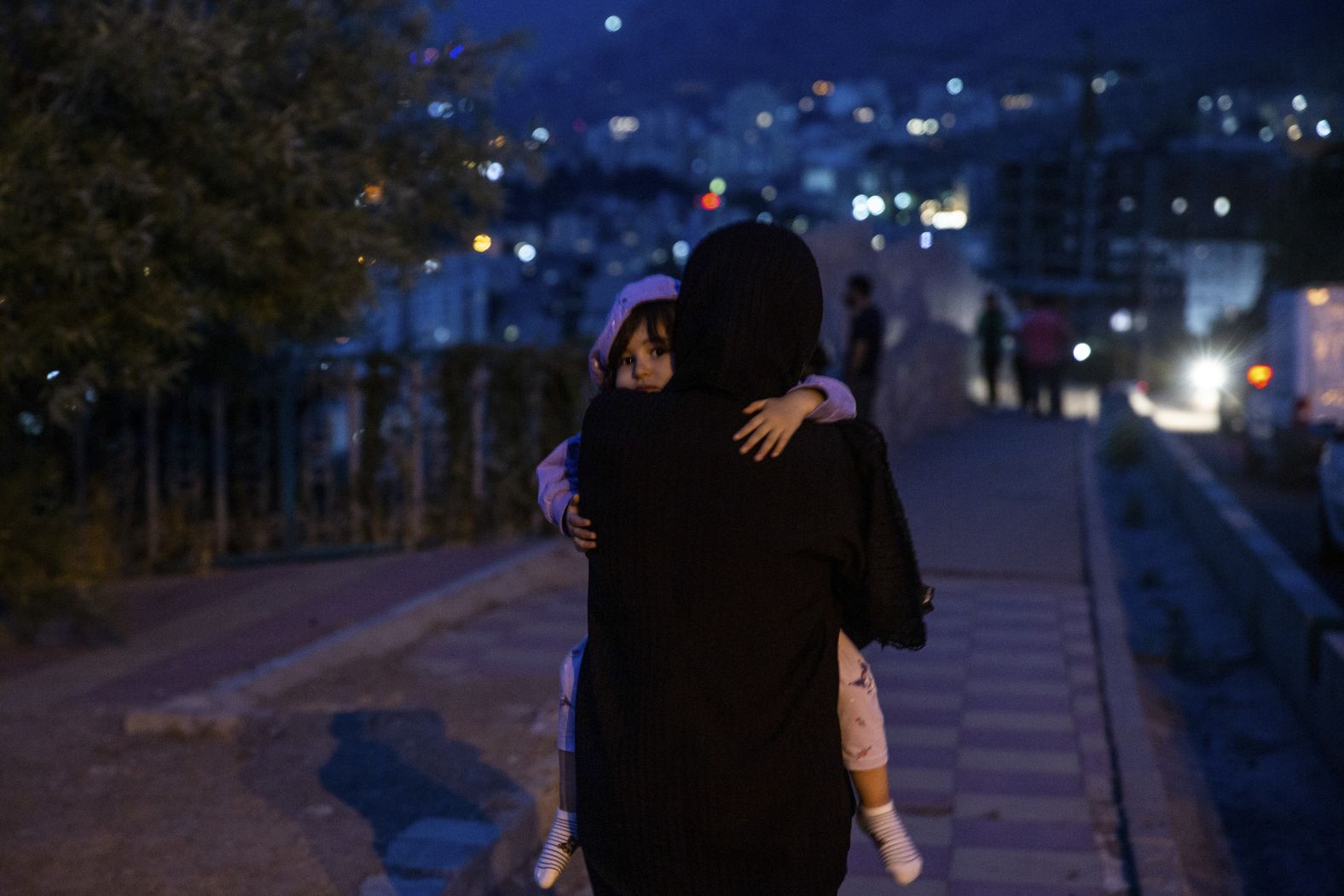 A child is carried through a street in Tehran after hearing explosions early on Friday.
