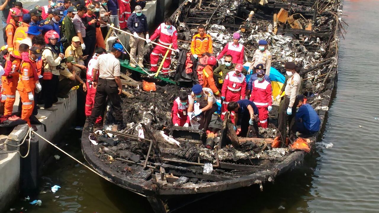 Rescuers search the charred passenger boat which was ferrying around 200 people off the coast of Jakarta to Tidung island, a tourist destination close to the capital when a fire started on January 1, 2017.