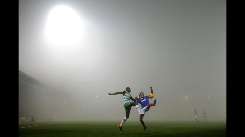 Players from Yeovil Town and Portsmouth compete for a ball during a foggy soccer match in Yeovil, England, on Friday, December 30. The two clubs play in League Two, which is the fourth tier of pro soccer in England.