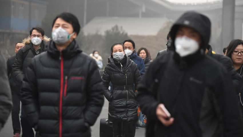 Commuters wear masks on a polluted day in Beijing on December 20, 2016. 
Heavy smog suffocated northeast China for a fifth day on December 20, with hundreds of flights cancelled and road and rail transport grinding to a halt under the low visibility conditions. / AFP / Greg Baker        (Photo credit should read GREG BAKER/AFP/Getty Images)