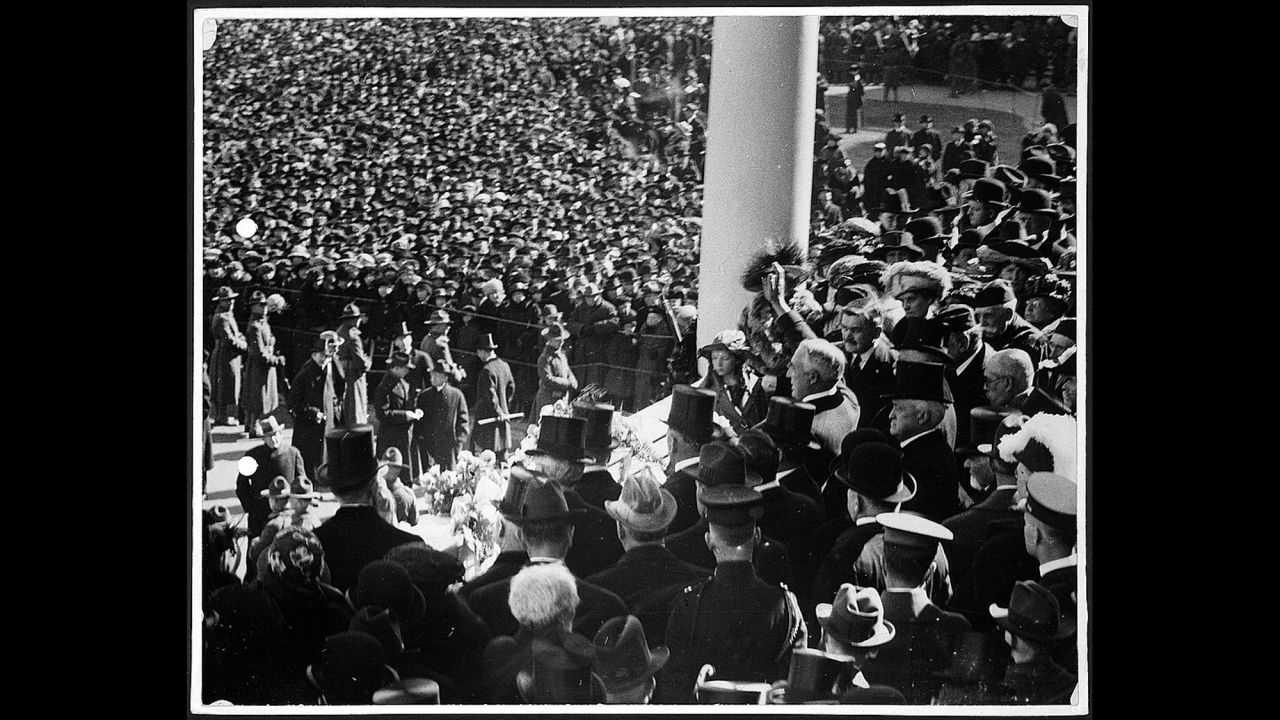 President Warren G. Harding waves to the crowd from the US Capitol's east portico in 1921. It was the first inauguration where an automobile was used to transport the president-elect to the Capitol.