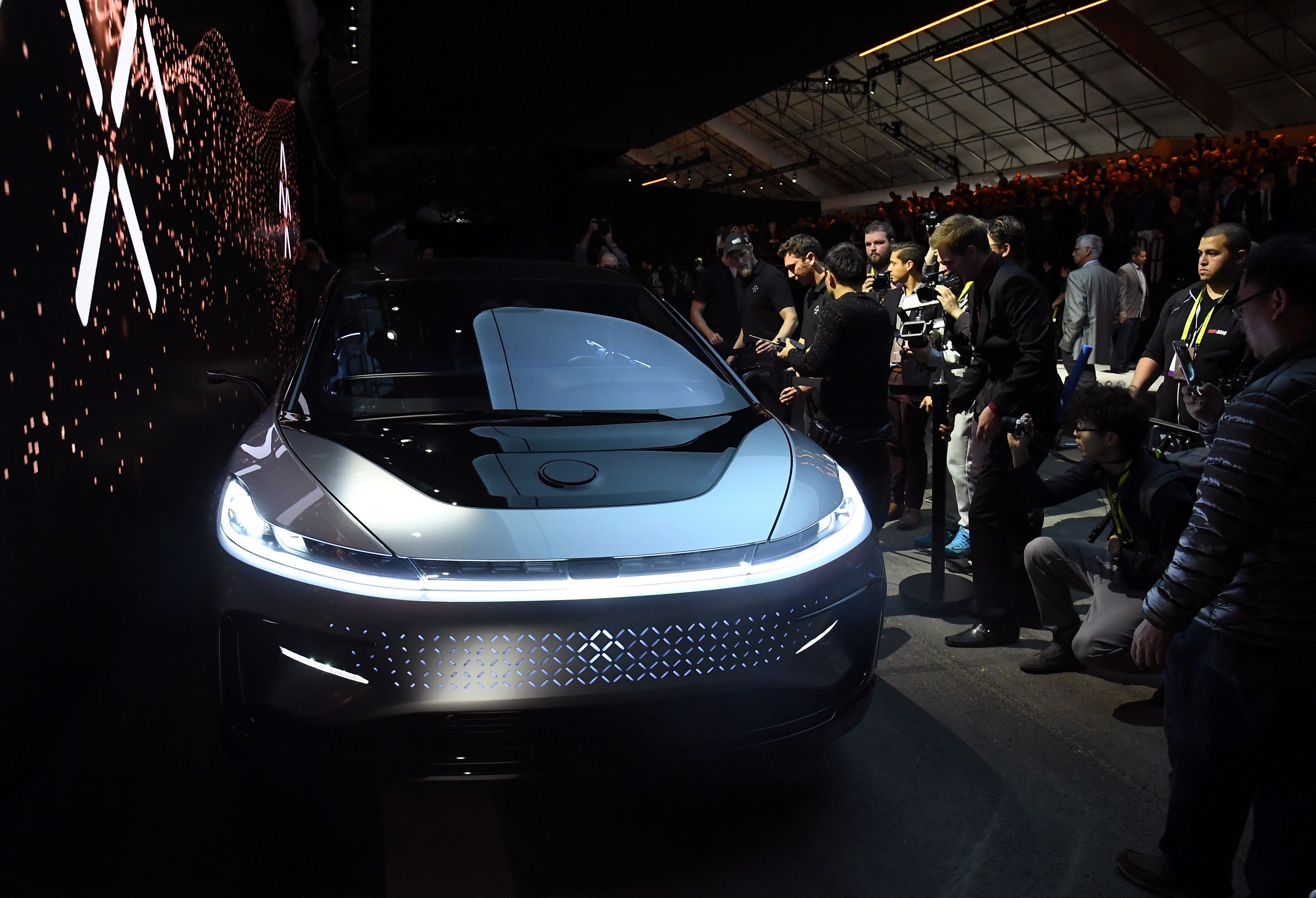 Attendees inspect the 4-door electric sedan, which Faraday Future executives called "a new species." <br /><br /><a href="index.php?page=&url=http%3A%2F%2Fmoney.cnn.com%2F2017%2F01%2F04%2Ftechnology%2Ffaraday-future-ces-2017%2Findex.html">READ: CNN Money's report on the FF91 launch</a>