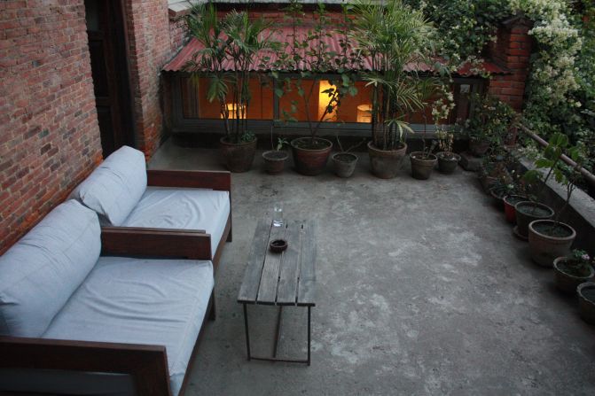 A private terrace off one of the hotel's rooms. The property's original features, such as its wooden beams and layout, have been retained.