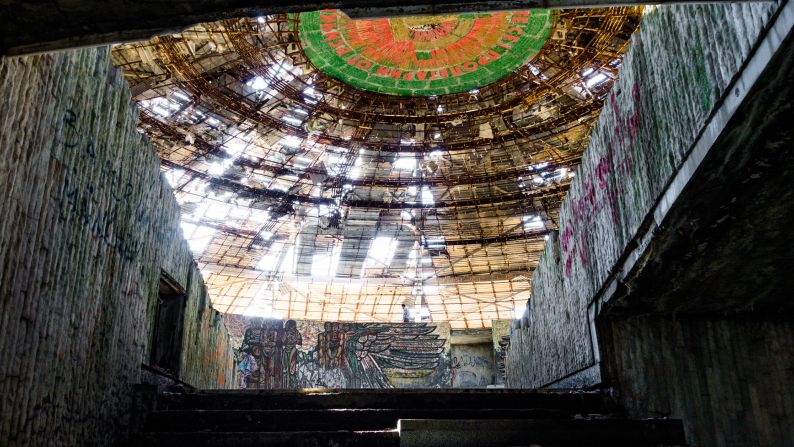 <strong>Entering the hall: </strong>Steps lead up to an auditorium illuminated by light pouring through the broken roof.