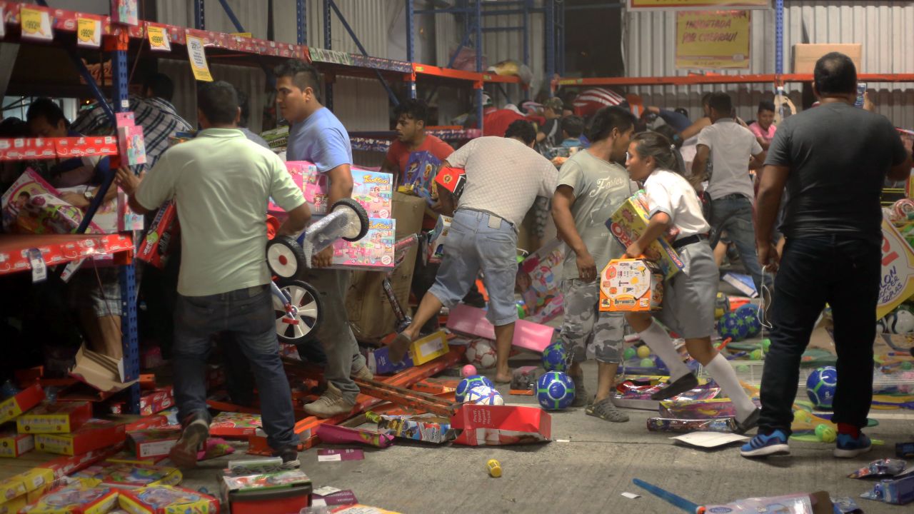 People pick up toys as they loot a store during a protest in the port city of Veracruz, Mexico, on Wednesday.
