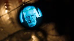 Julian Assange, founder of the online leaking platform WikiLeaks, is seen through the eyepeace of a camera as he is displayed on a screen via a live video connection during a press conference on the platform's 10th anniversary on October 4, 2016 in Berlin.