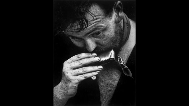 A man plays a harmonica in Washington Square Park.