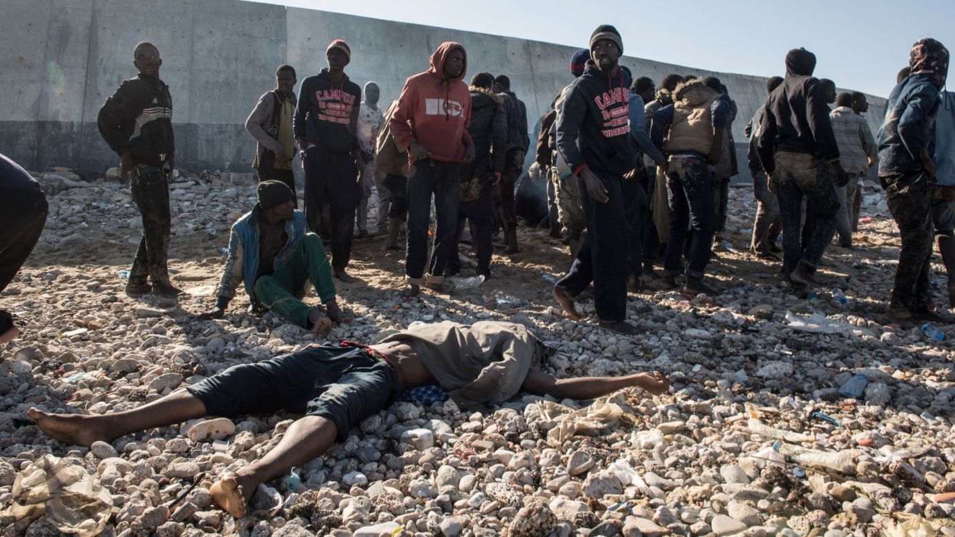 Migrants stand next to a dead body after their boat washed ashore in Tripoli, Libya, on Wednesday, January 4. The migrants, mostly from Senegal, had left Sabratha, Libya, hoping to reach Europe. They spotted land and thought it was Italy, and several drowned trying to swim to shore. <a href="http://www.cnn.com/2015/09/03/world/gallery/europes-refugee-crisis/index.html" target="_blank">Europe's migration crisis in 25 photos</a>