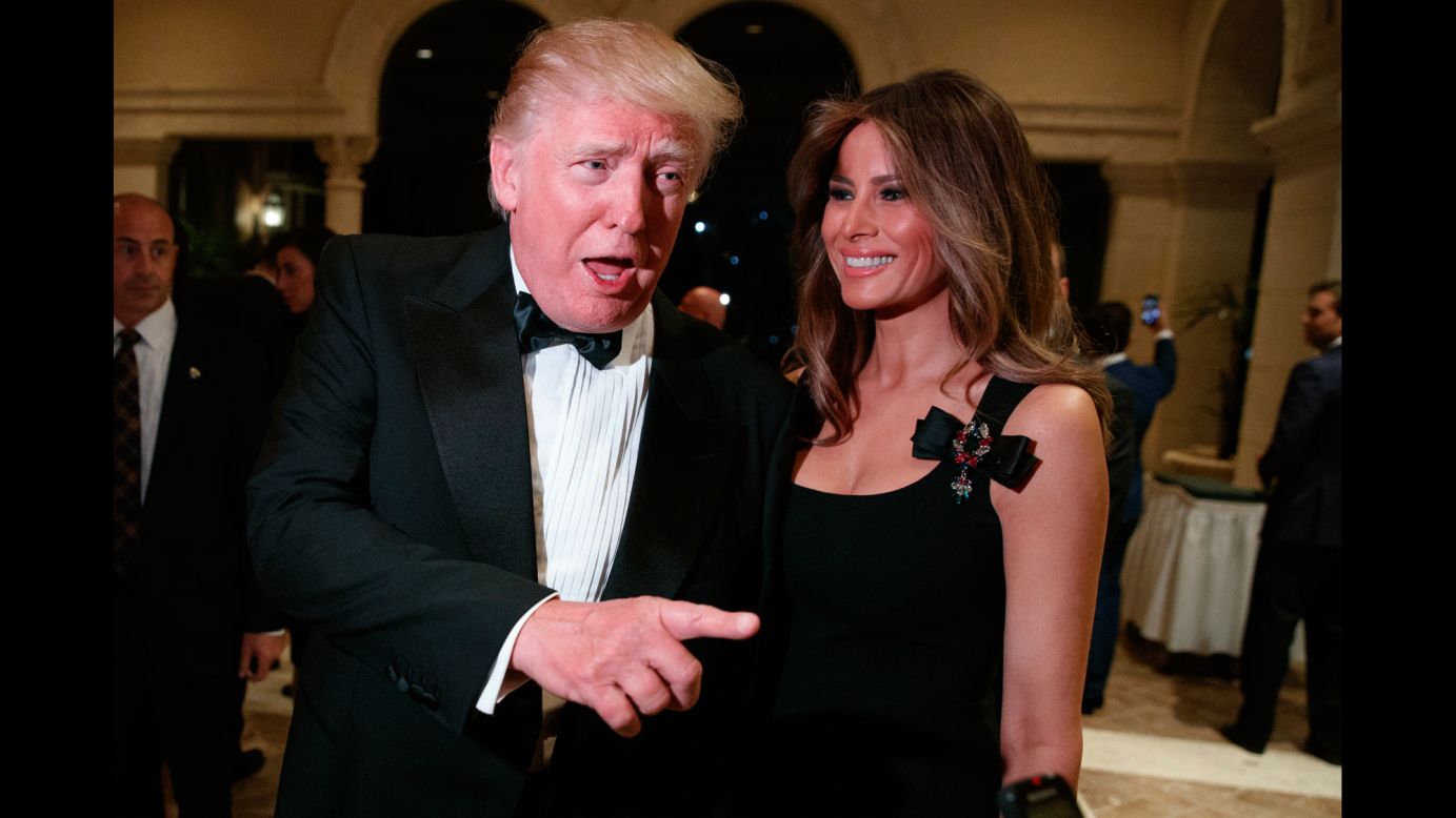 President-elect Donald Trump, accompanied by his wife, Melania, talks to reporters during a New Year's Eve party at his Mar-a-Lago resort in Palm Beach, Florida.