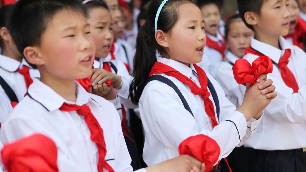 Chinese students wearing the uniform of the Young Pioneers.
