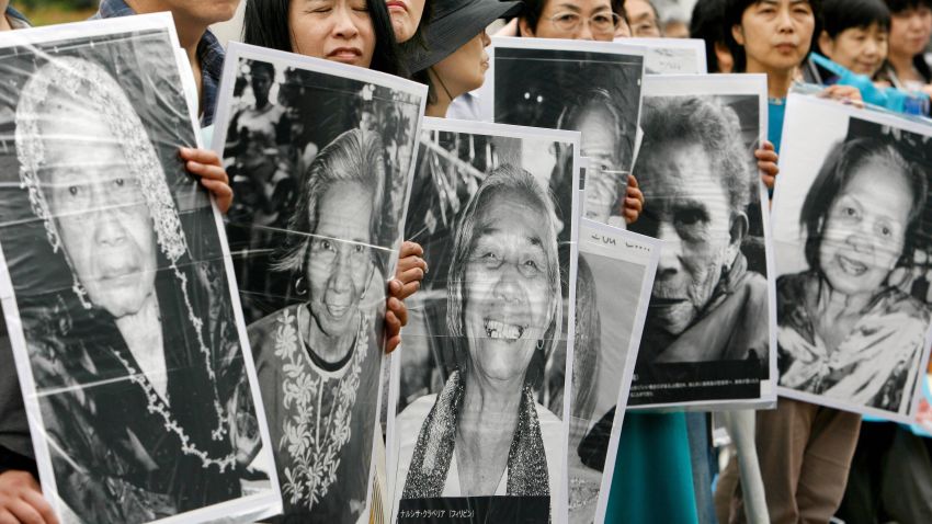 Tokyo, JAPAN: Japanese women hold portraits of Chinese, Philippine, South Korean and Taiwanese former comfort women who were sex slaves for Japanese soldiers during World War II, at a protest held in front of the Japanese parliament in Tokyo, 14 June 2007. About 150 people took part in the protest demanding compensation by the Japanese government.    AFP PHOTO/Toru YAMANAKA (Photo credit should read TORU YAMANAKA/AFP/Getty Images)