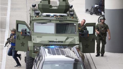 Law enforcement personnel arrive in an armored car outside the airport. 
