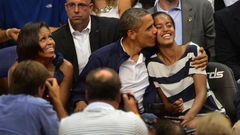 Obama gives Malia a hug and a kiss after not kissing his wife, Michelle, on the "Kiss Cam" at the Verizon Center in July 2012. 