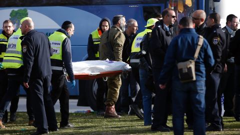Israeli medics carry a covered body from the scene of the attack.