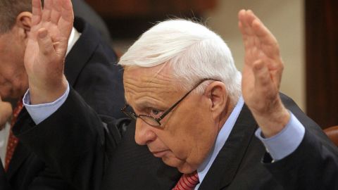 Israeli Prime Minister Ariel Sharon raises his hand while voting for a bill to compensate settlers leaving Gaza.