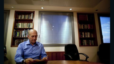 Former Israeli Prime Minister Ehud Olmert poses for photographers at his office in 2010.