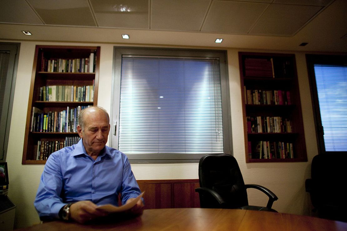 Former Israeli Prime Minister Ehud Olmert poses for photographers at his office in 2010.