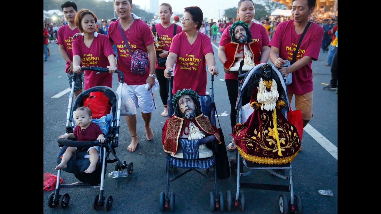 A family uses baby strollers to carry replicas of the image of the Black Nazarene on January 9.