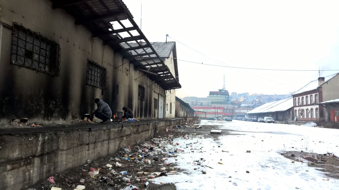 Asylum seekers light fires to keep warm at an abandoned warehouse in Belgrade.