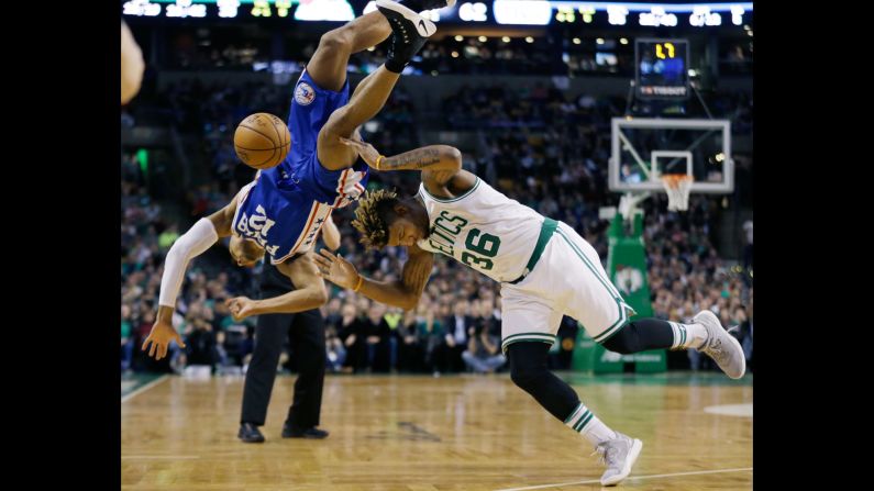 Philadelphia's Gerald Henderson, left, falls over Boston's Marcus Smart while trying to block a shot on Friday, January 6.