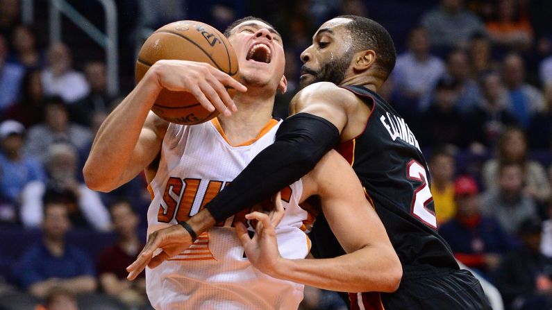 Phoenix guard Devin Booker is fouled by Miami's Wayne Ellington during an NBA game in Phoenix on Tuesday, January 3.