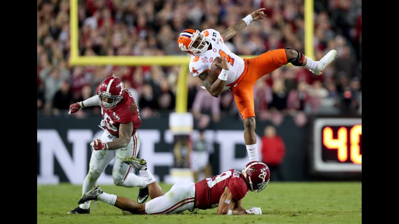 Watson spins in the air after being hit by Alabama defenders in the third quarter.