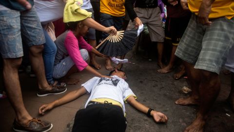 A devotee collapses during the procession to Quiapo Church along a road in Manila.