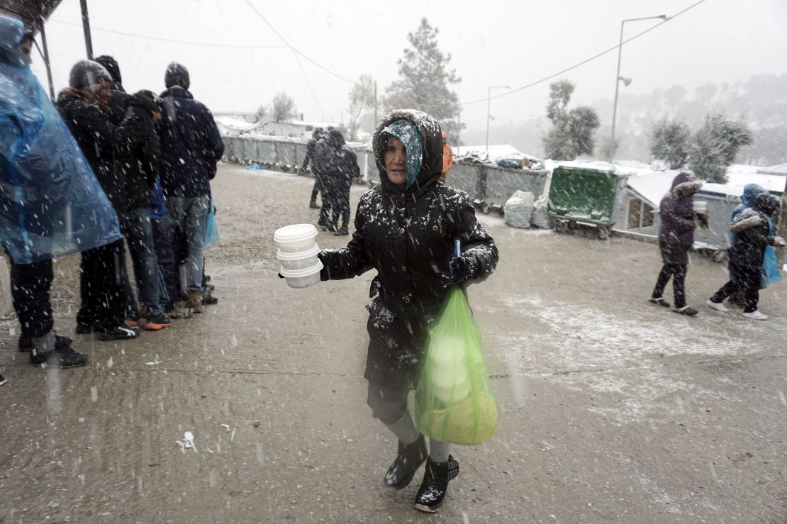 A migrant receives food during snowfall at the Moria camp on Lesbos, on January 9, 2017.