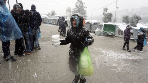 A migrant receives food during snowfall at the Moria camp on Lesbos, on January 9, 2017.