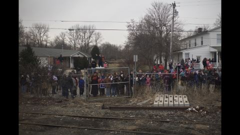A crowd of people watches a train carrying President-elect Barack Obama to Washington on January 17, 2009. He was on a whistle-stop train tour three days before his inauguration, and photographer Nina Berman was on board.