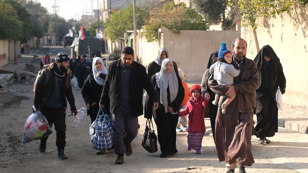 Iraqi civilians fleeing their neighbourhoods due to the ongoing fighting with Islamic State (IS) group jihadists arrive to the northern edge of al-Mithaq neighbourhood in southeastern Mosul, on January 4, 2017. 