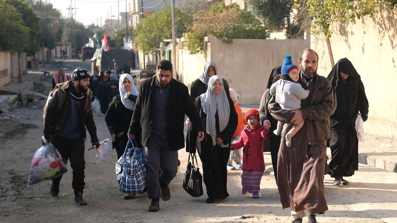 Iraqi civilians fleeing their neighbourhoods due to the ongoing fighting with Islamic State (IS) group jihadists arrive to the northern edge of al-Mithaq neighbourhood in southeastern Mosul, on January 4, 2017.
