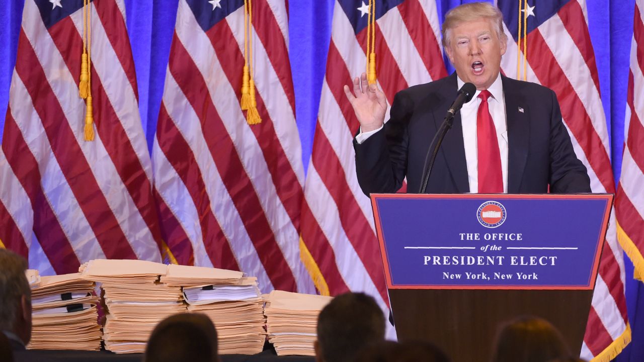 Numerous files are displayed, left, as US President-elect Donald Trump gives a press conference January 11, 2017 in New York.