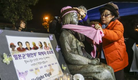 Supporters place a scarf and hat on the Glendale memorial statue during a candlelit vigil in January 2016. 