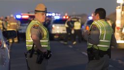 Emergency personnel gather at the scene where an Arizona Department of Public Safety trooper was shot, Thursday, Jan. 12, 2017, at the scene of a rollover accident on Interstate 10 near Tonopah, Ariz. An Arizona state trooper stopped to help at a car wreck along the remote highway Thursday when he was shot and wounded in an ambush by a man who was bashing the officer's head against the pavement until a passing driver shot him to death, authorities said.   The trooper suffered a severe wound to his shoulder and upper chest but he is expected to recover at a hospital.
(Mark Henle/The Arizona Republic via AP)