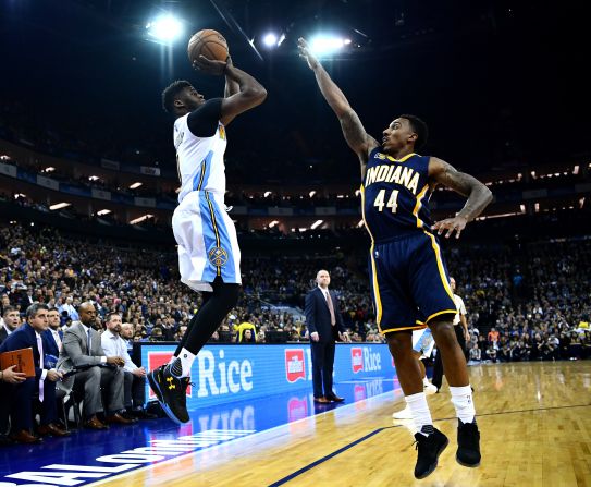 Pacers' Jeff Teague tries to block Emmanuel Mudiay of the Nuggets under the lights of London's O2 Arena. 