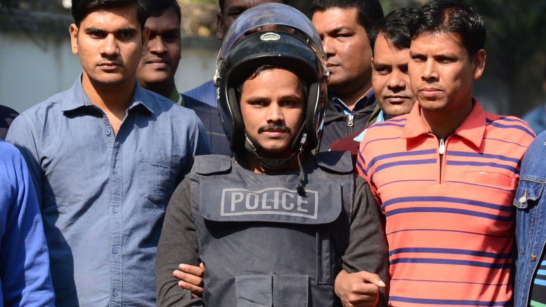 Bangladesh police escort suspect Jahangir Alam, in body armor, in Dhaka on Saturday after his arrest. 