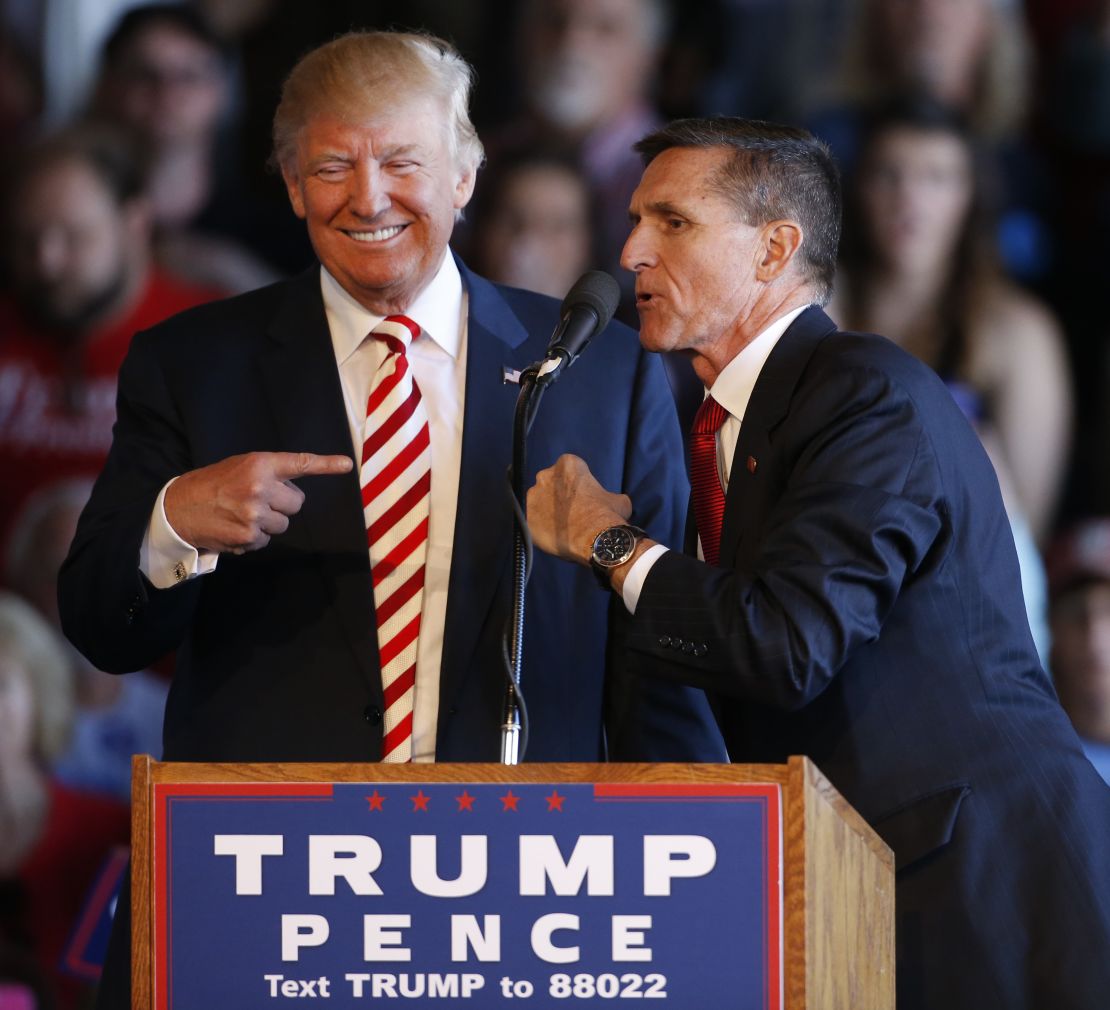 Donald Trump jokes with retired Gen. Michael Flynn as they speak at a rally at Grand Junction Regional Airport on October 18, 2016.
