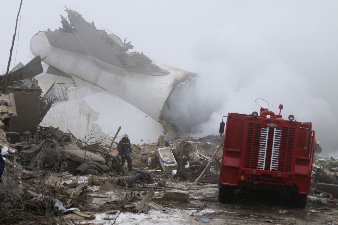 A Kyrgyz firefighter inspects the plane crash site.