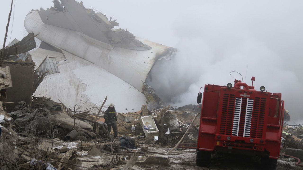 A Kyrgyz firefighter inspects the plane crash site.