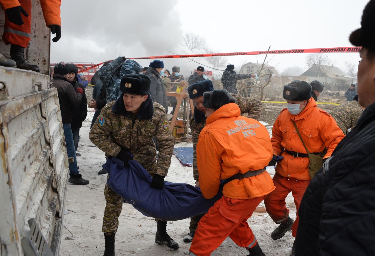 Rescuers carry the body of a victim at the crash site on January 16. At least 37 people were killed, and the death toll is likely to rise, according to a statement from Kyrgyzstan's Ministry of Emergency Situations.
