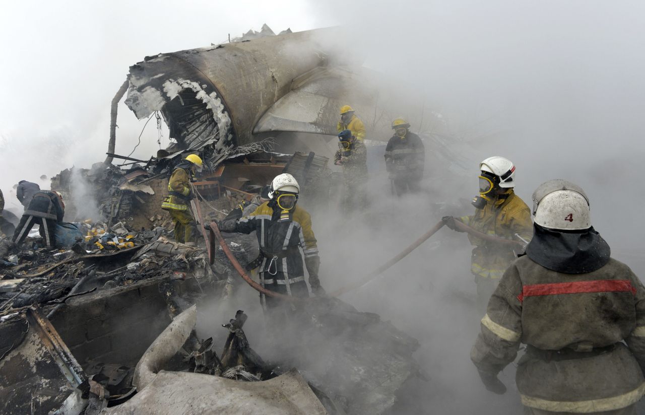 Kyrgyz firefighters work in the wreckage of the plane.