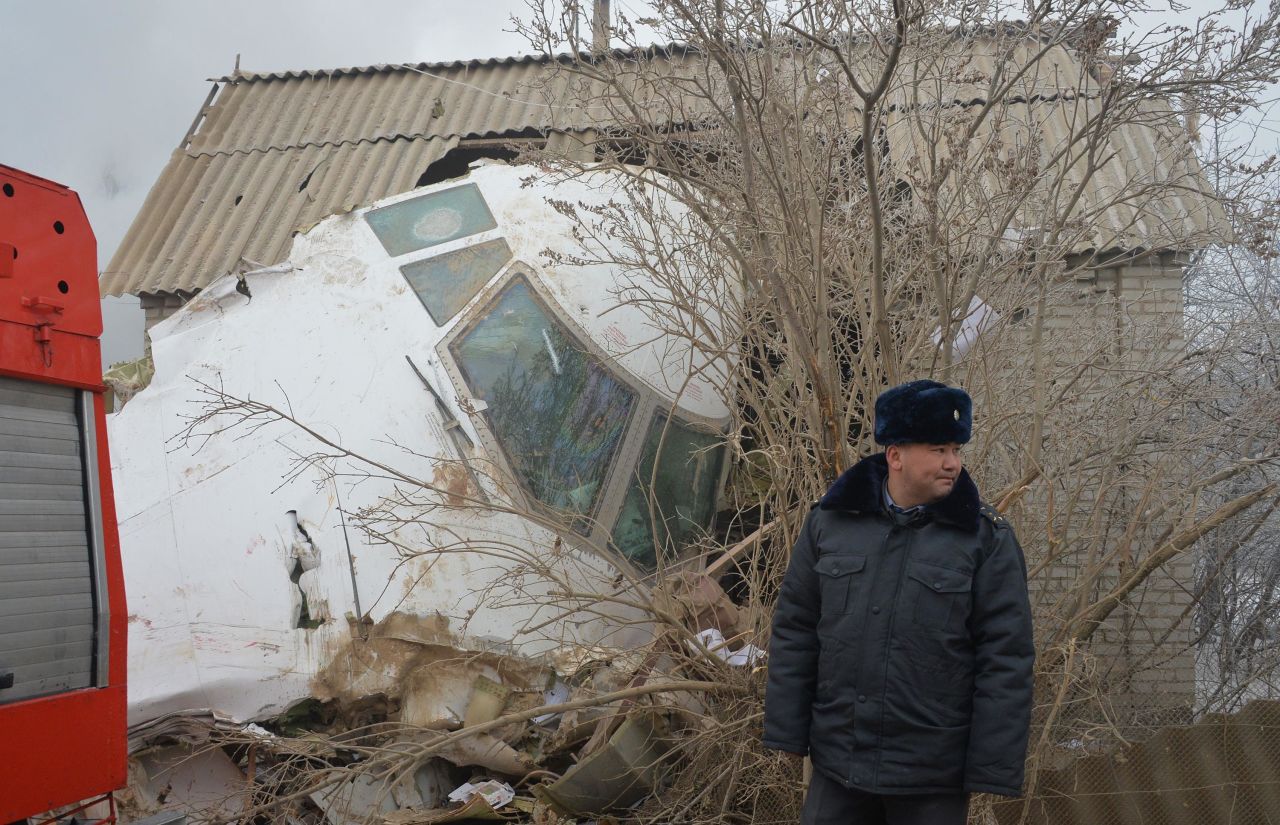 An official stands by the wreckage of the cargo plane, which crashed at 7:18 a.m. local time about 2  kilometers (1.2 miles) away from Manas airport, according to Kabar.