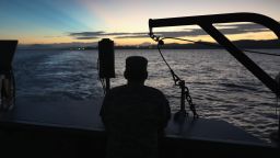 GUANTANAMO BAY, CUBA - OCTOBER 24:  (EDITORS NOTE: Image has been reviewed by the U.S. Military prior to transmission.) A U.S. soldier looks towards the first rays of sunlight while on a dawn ferry near the military prison known as "Gitmo" on October 24, 2016 at at the U.S. Naval Station at Guantanamo Bay, Cuba. The U.S. military's Joint Task Force Guantanamo is holding 60 detainees at the prison, down from a previous total of 780. In 2008 President Obama issued an executive order to close the prison, which has failed because of political opposition in the U.S.  (Photo by John Moore/Getty Images)