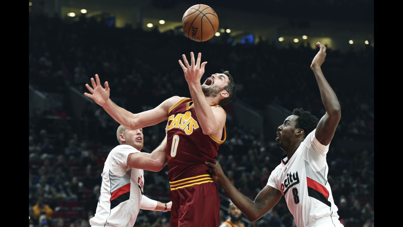 Cleveland Cavaliers forward Kevin Love battles for a rebound with Portland Trail Blazers center Mason Plumlee, left, and forward Al-Farouq Aminu in the first half of an NBA basketball game on January 11 in Portland, Oregon.