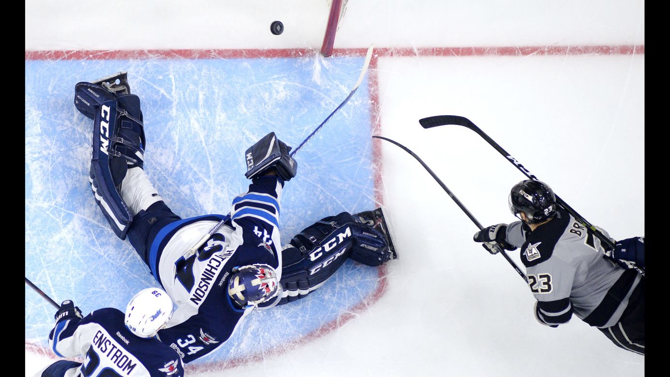 Los Angeles Kings' Dustin Brown, right, scores on Winnipeg Jets goalie Michael Hutchinson during the third period of an NHL hockey game on Saturday, January 14. The Kings won 3-2 in overtime.