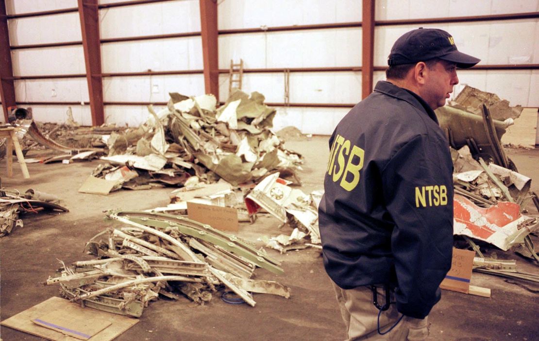 A National Transportation Safety Board Official stands with piles of wreckage from EgyptAir Flight 990 on November 1, 2000.