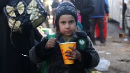 A Syrian girl evacuated from the last rebel-held pockets of Syria's northen city of Aleppo, eats upon arriving in the opposition-controlled Khan al-Assal region on December 20, 2016.