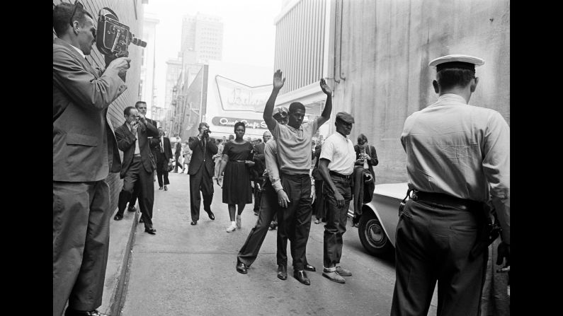 A police officer in Birmingham, Alabama, frisks a demonstrator after an attempted sit-in on April 15, 1963.
